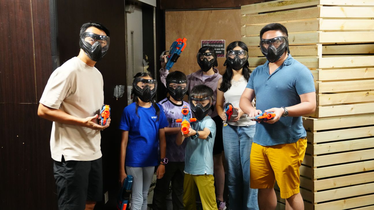 Happy family and friends enjoying nerf wargame